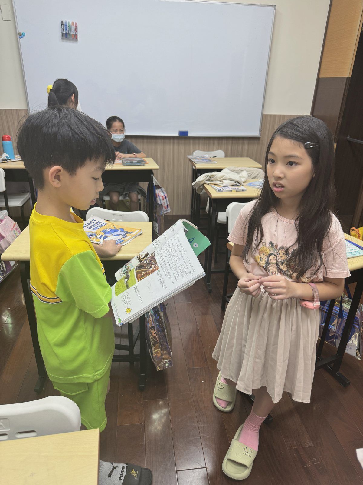 孩子拿著課本互相問答複習